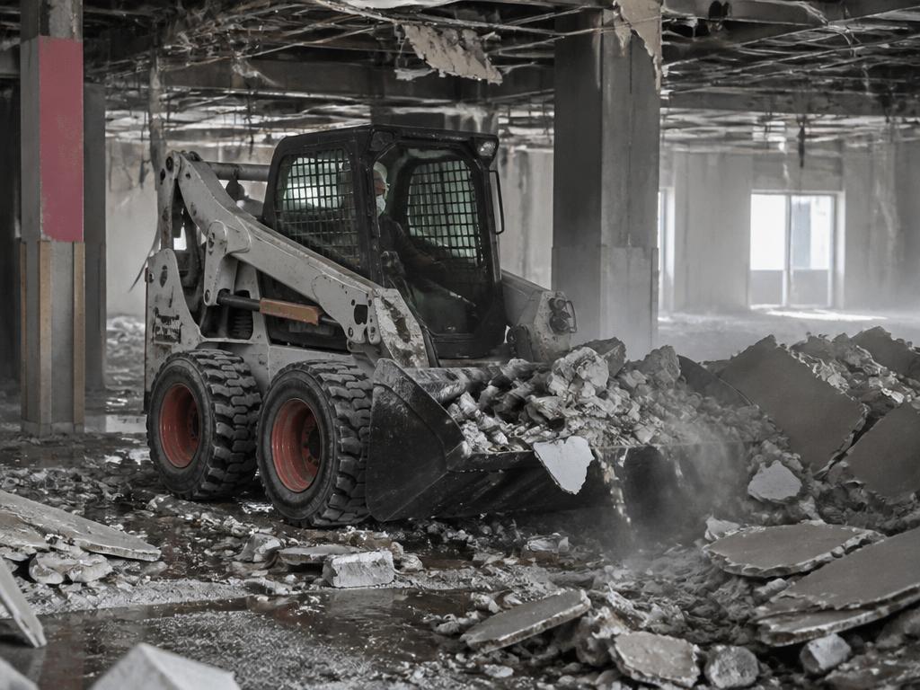 Skid steer loader clearing demolition debris
